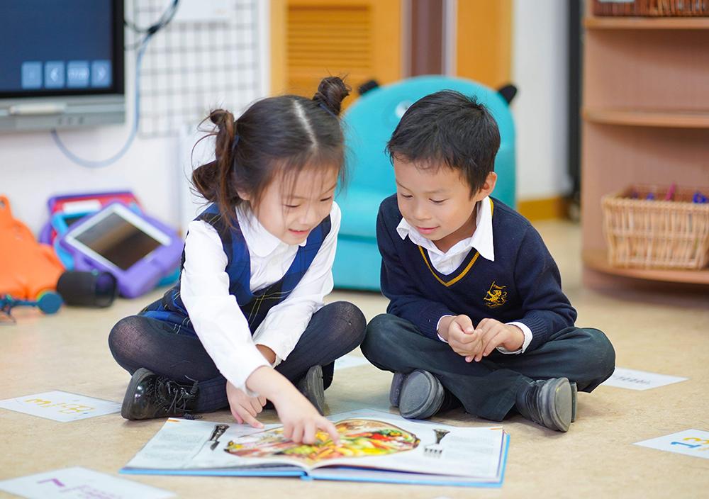 Two Early Years students reading a picture book together at Hiba Academy Bay Area, a private international preschool in San Francisco Bay Area.