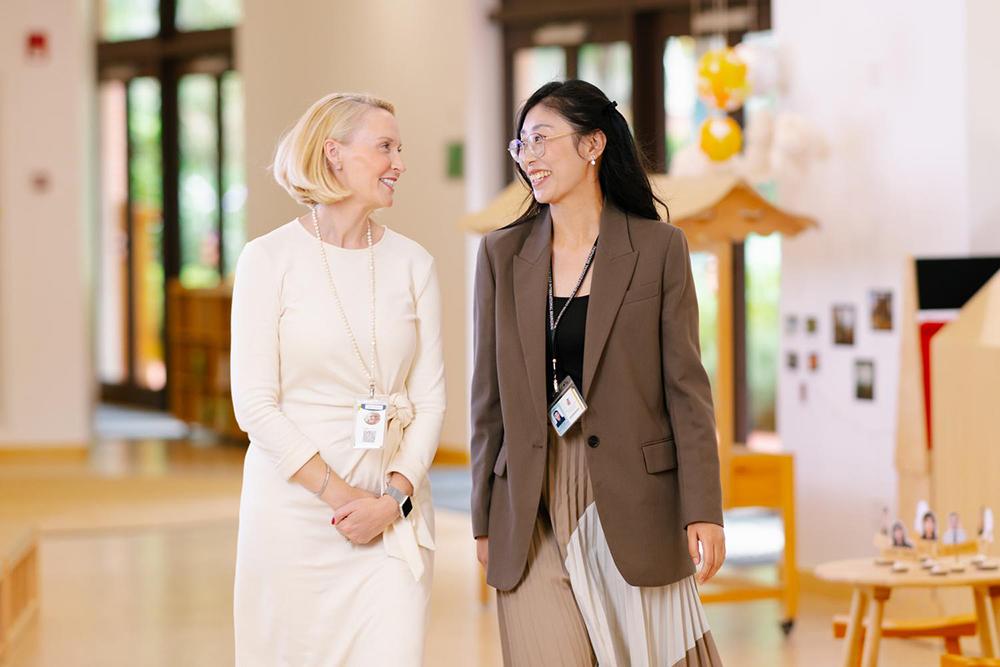 Two teachers exchange smiles, reflecting on the advantages of pursuing a career in education at Hiba Academy Bay Area, an international school in San Francisco.