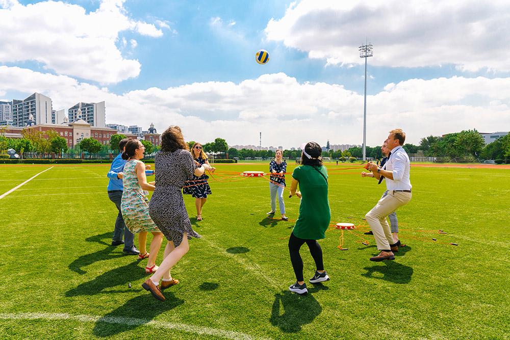 Teachers from diverse backgrounds enjoy an outdoor team building activity on a field, showcasing the inclusive teaching community at Hiba Academy Bay Area, an international school in San Francisco.