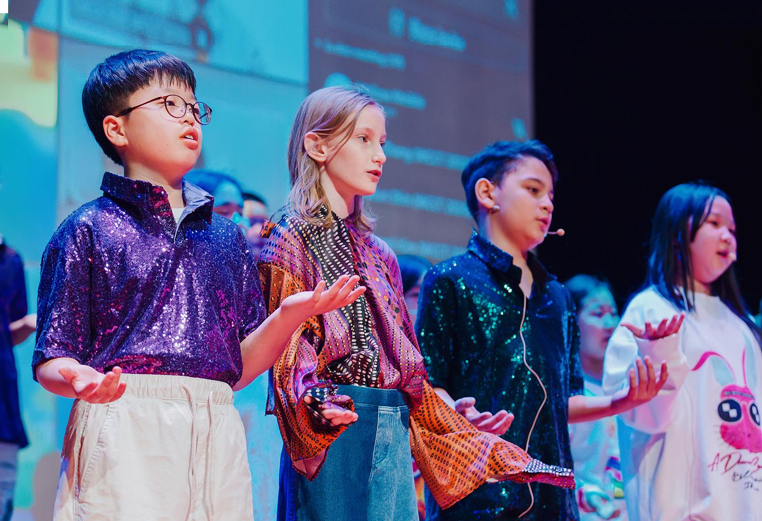 Elementary school students perform on stage at Hiba Academy Bay Area, an international primary school in San Francisco Bay Area offering International Baccalaureate, International Primary Curriculum, and social and emotional learning programs.