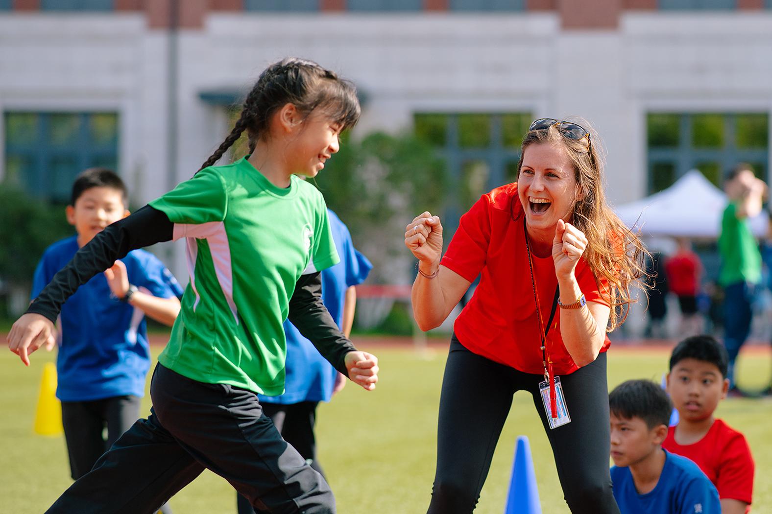 A primary school teacher cheers a student athlete on at Hiba Academy Bay Area, a private dual-language elementary school in San Francisco with International Baccalaureate, International Primary Curriculum, and social and emotional learning programs.