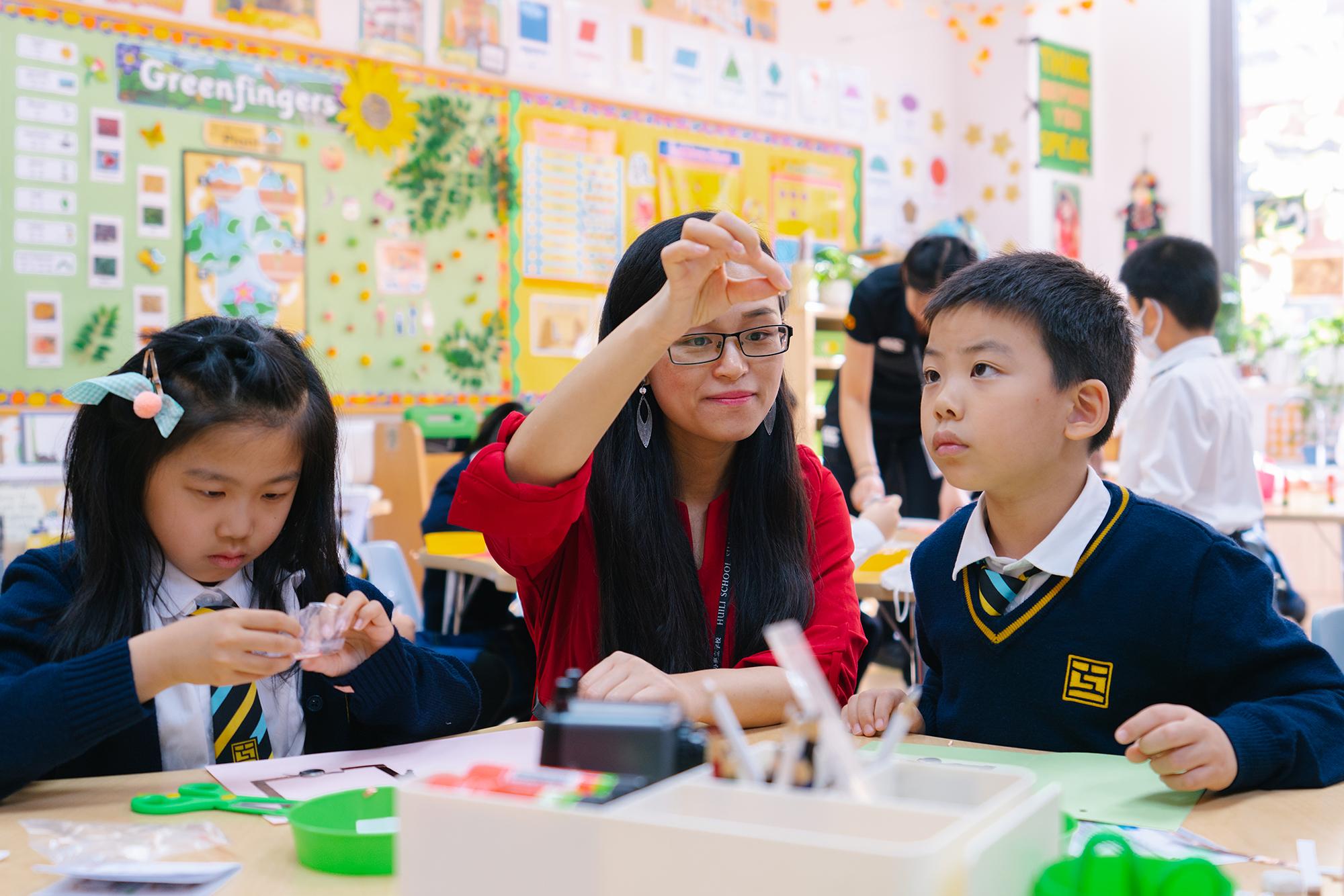 A teacher engages in hands-on learning with two students at Hiba Academy Bay Area, a dual-language elementary school in San Francisco with International Baccalaureate, International Primary Curriculum, and social and emotional learning programs.