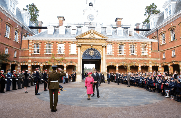 Queen Elizabeth II walks through the campus of an academy under the Wellington College Education Network of schools in UK as students look on.